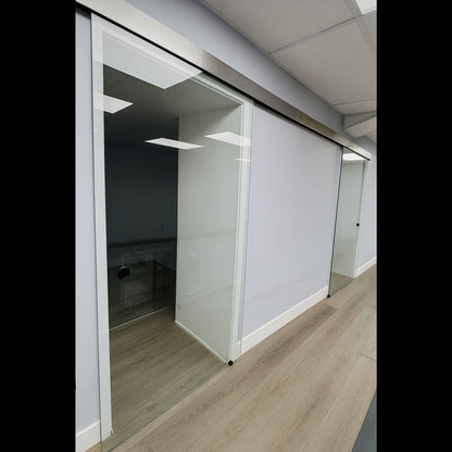Hydraulic sliding door system kit installed, showing metal tracks, hydraulic components, and glass door for smooth operation.